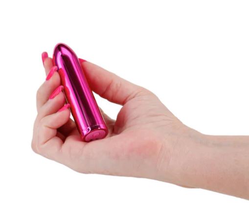 NS Novelties Chrome Petite Bullet Vibrator Pink held in a hand, showcasing its sleek design and vibrant color.