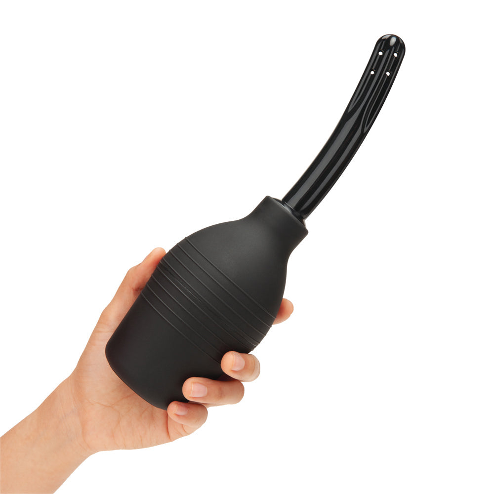 b-Vibe Essentials Enema Douche With Nozzle 310 ml Black in hand, showcasing the flexible bulb and smooth nozzle.