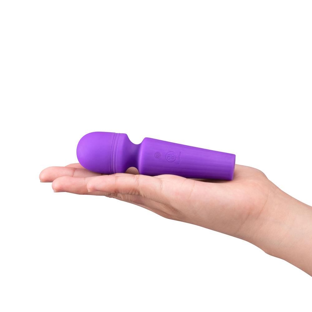 Together Glow On The Go Mini Wand Vibrator Purple held in a hand, showcasing its compact design and silicone finish.