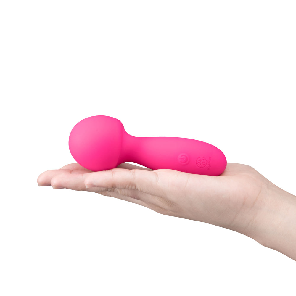 Together Spark On The Go Mini Wand Vibrator held in a person's hand, showcasing its compact and vibrant design.