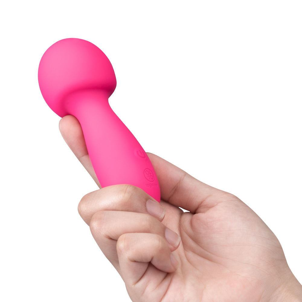 Together Spark On The Go Mini Wand Vibrator held in a hand, designed for travel and pleasure.