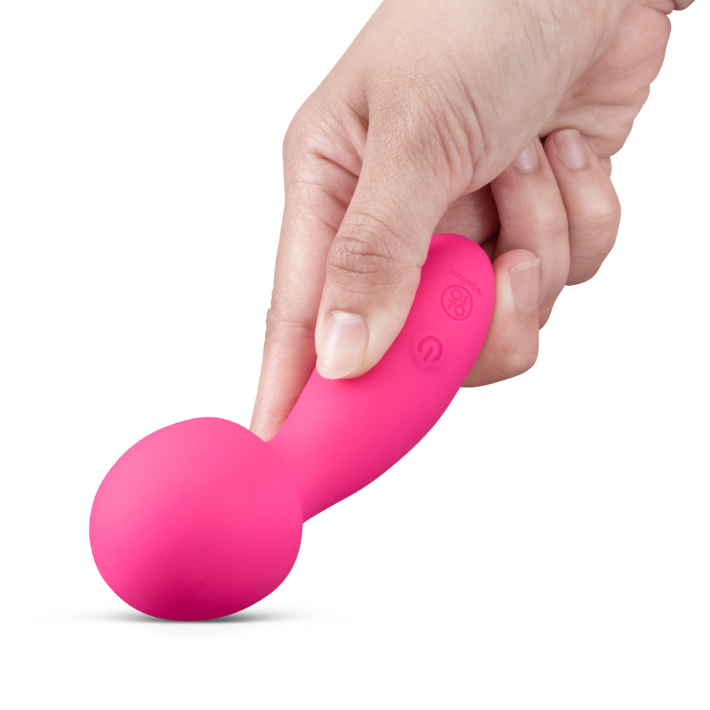 Together Spark On The Go Mini Wand Vibrator held in hand showcasing vibrant pink color and sleek design.