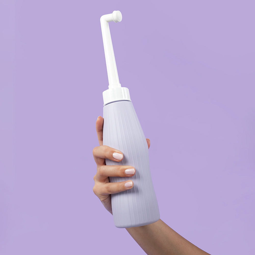 Uva Vaginal & Perineal Wash Bottle in hand showcasing its ergonomic design for intimate hygiene.