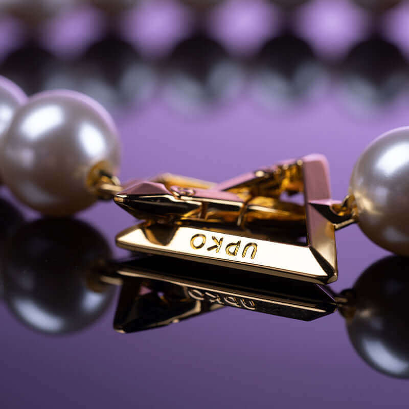 Close-up of UPKO 'Moist Eyes' Pearl Anklet featuring elegant pearls and a gold clasp with the UPKO brand logo.