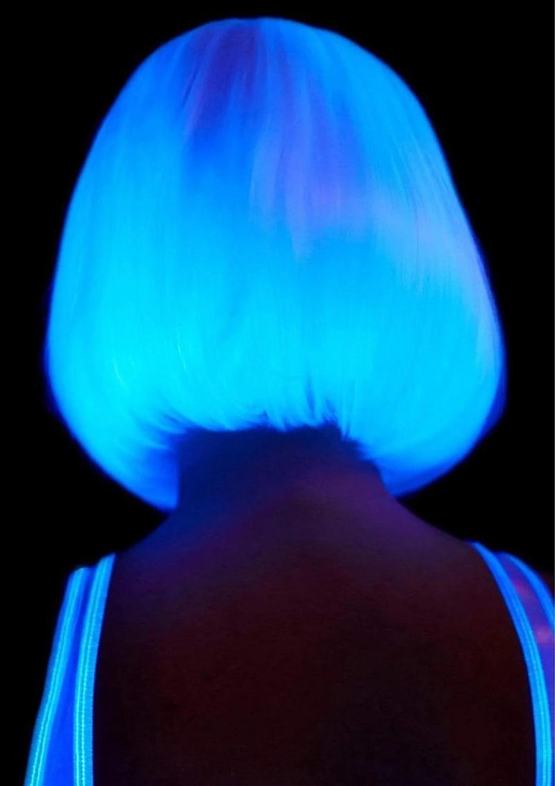 Leg Avenue Pearl Short Natural Bob Wig White glowing in blue light, showcasing sleek bob hairstyle.