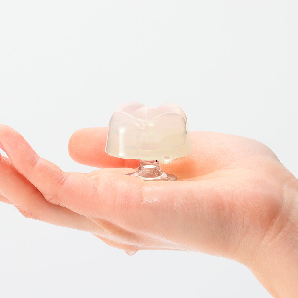 Iroha Petit Lily Disposable Clitoral Massager Clear held in hand, featuring a gel-like texture and compact design.