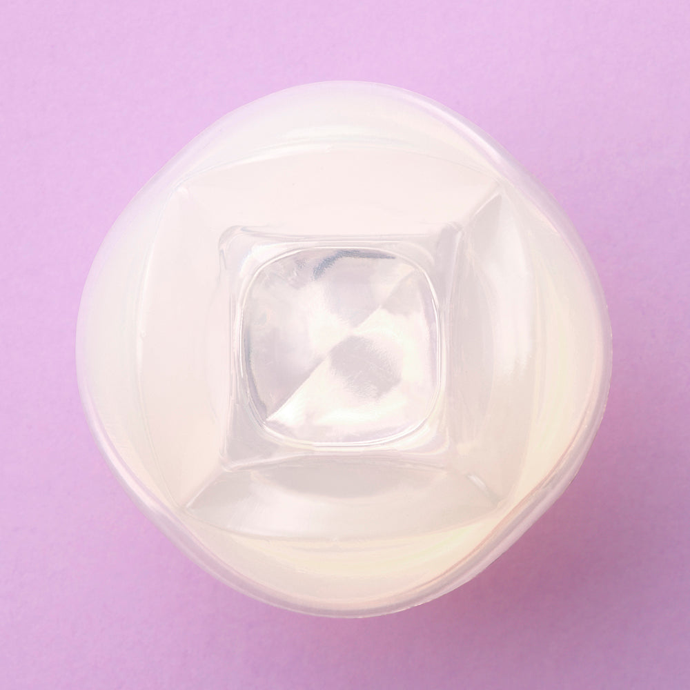 Iroha Petit Lily Disposable Clitoral Massager Clear viewed from above on a pastel purple background.