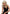 Pleasure Wigs Collection Aubrey Wig Blonde worn by a model with glamorous curls and a chic black dress.