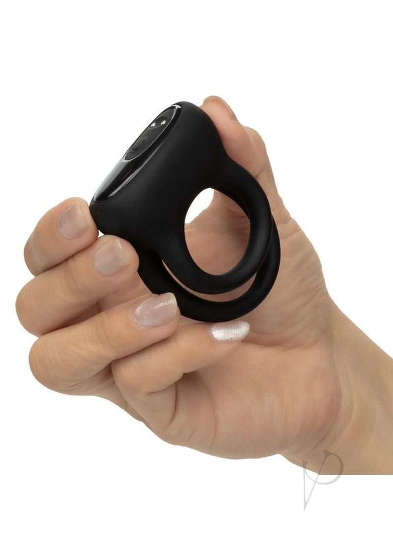 Pleasure Kits Power Play Collection Couples Kit Black dual enhancer ring held in hand, featuring sleek design for couples.