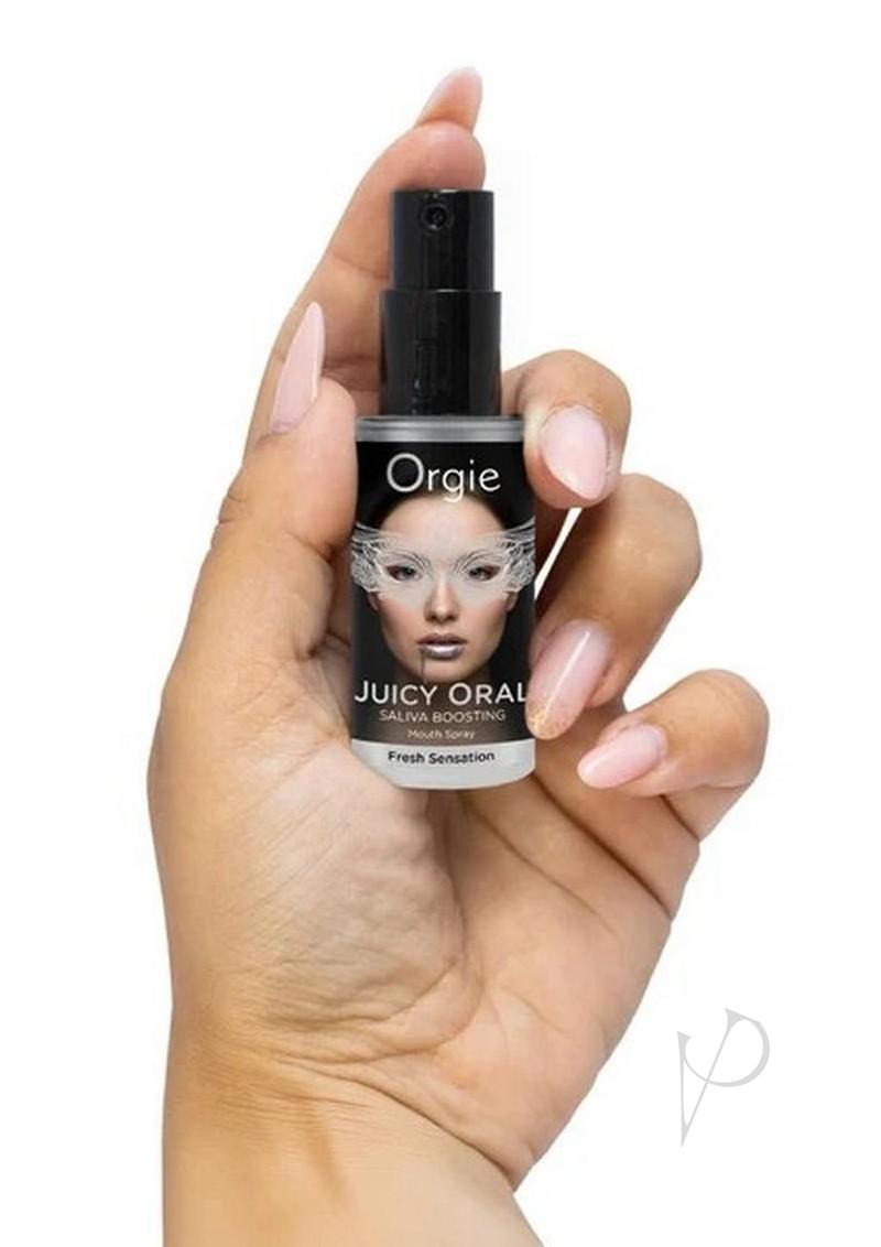 Orgie Juicy Oral Refreshing Mouth Spray 0.5 Oz Mint held in hand for fresh sensation and saliva boosting.