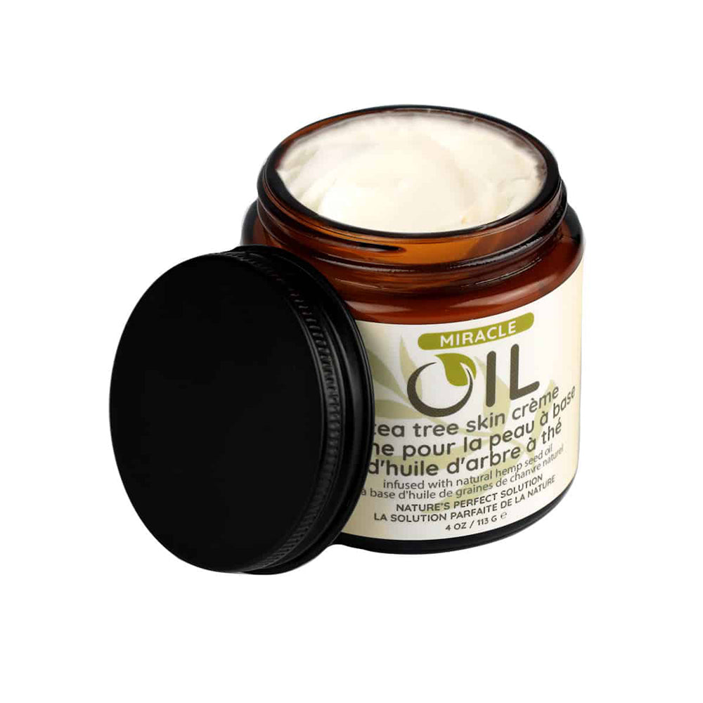Earthly Body Miracle Oil Tea Tree Creme 4 Oz in a jar with a black lid, featuring creamy texture and natural ingredients.