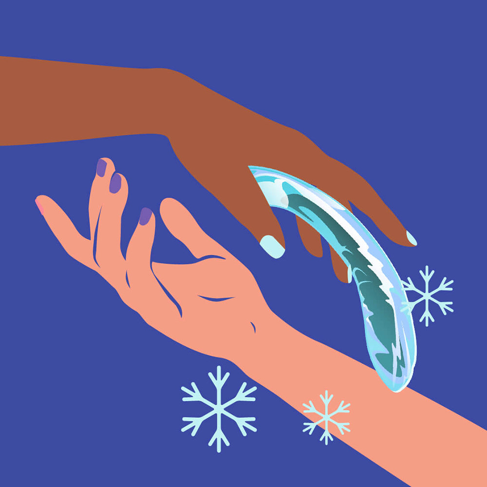 Hands reaching for the Biird Kalii Glass G-spot Dildo against a blue background with snowflakes.