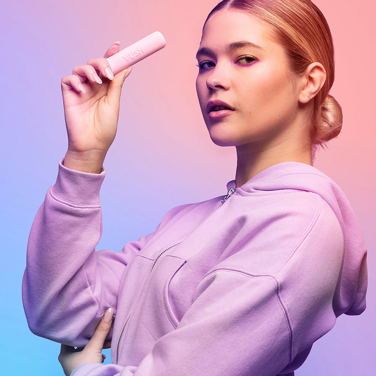 VUSH Gloss Bullet Vibrator held by a model in a pink hoodie, showcasing its sleek design and portability.