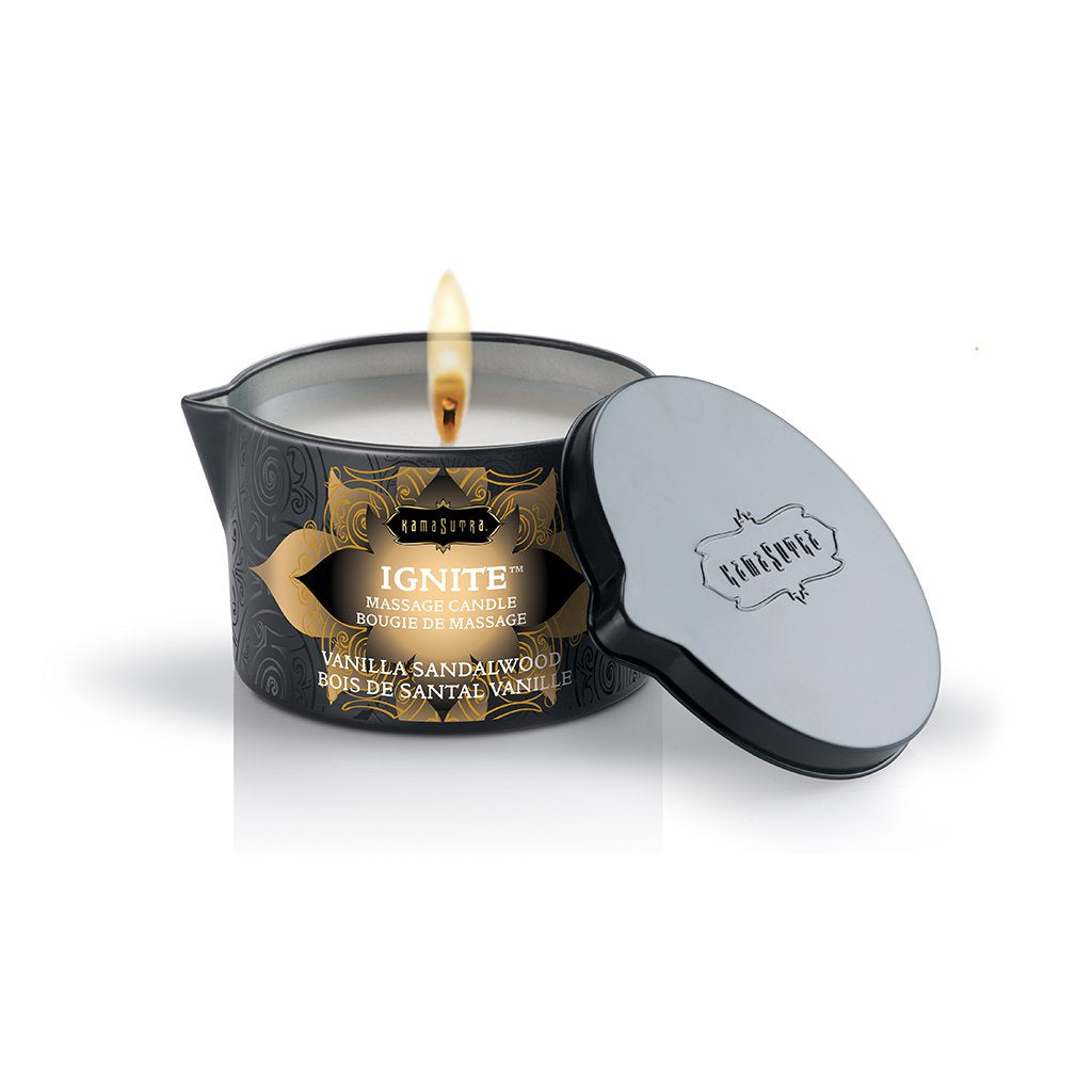 Kama Sutra Ignite Vanilla Sandalwood Massage Candle 6 Oz lit with elegant black container and silver lid.