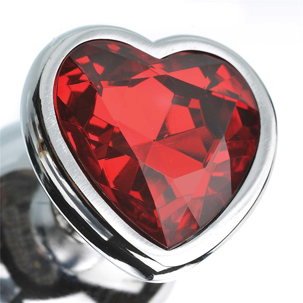 Close-up of the heart-shaped jewel from the Adam & Eve Three Hearts Gem Anal Plug Set, showcasing its red color and sparkling design.