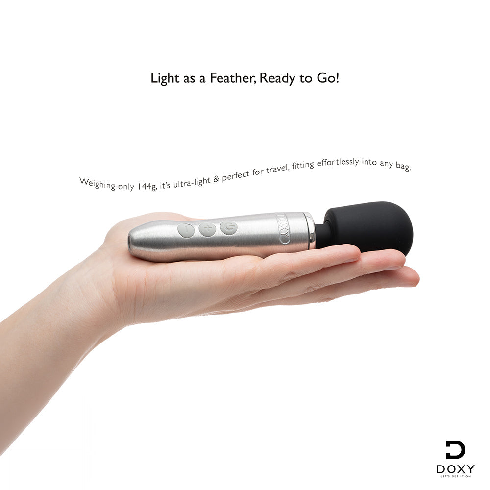 Doxy Go Travel-sized Wand Massager Silver held in hand, showcasing its lightweight and travel-friendly design.