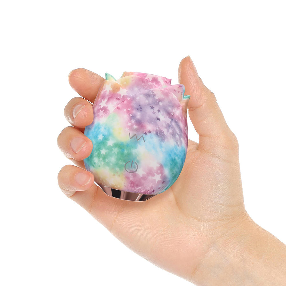 Adam & Eve Eves Ravishing Rose Tapping Clitoral Stimulator Rainbow held in a hand, showcasing its colorful galaxy finish.