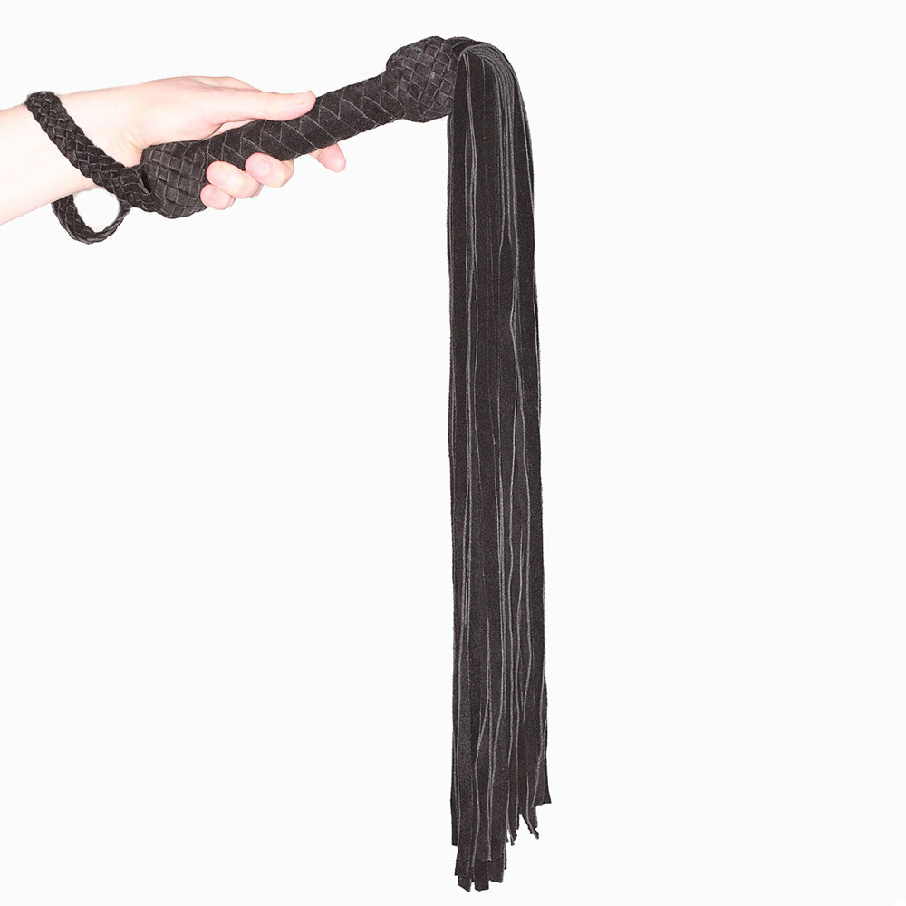 Prowler Red Leather Suede Flogger Black held in hand, showcasing its long black suede strands for sensual flogging.