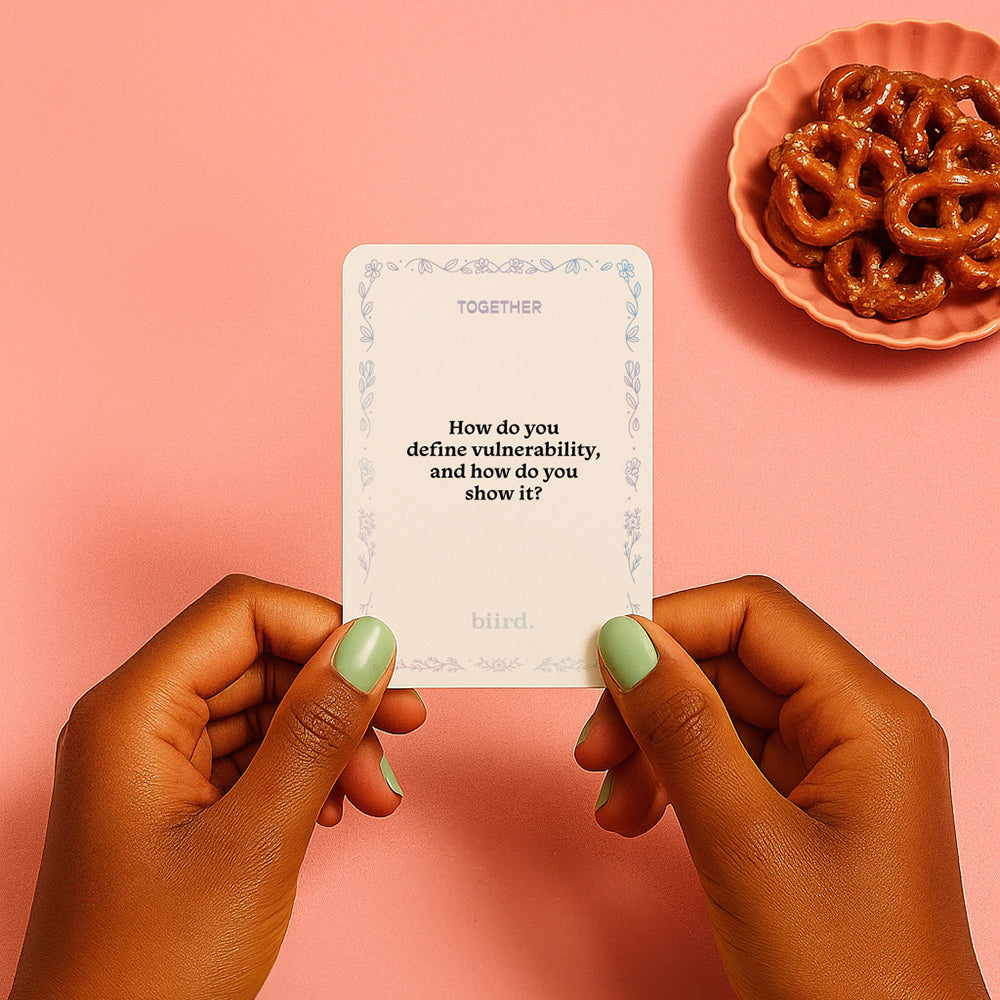 Person holding a card from Biird X Jouissance Club Together Couples Card Game asking about vulnerability.