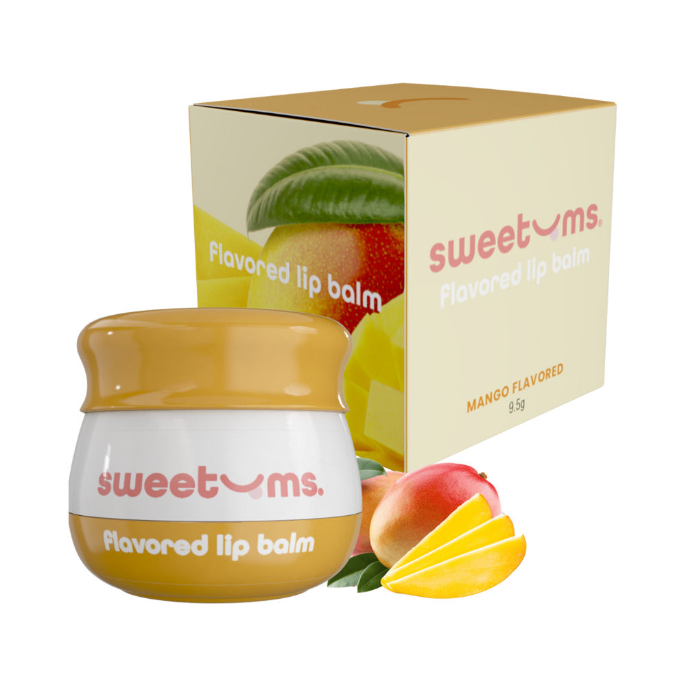 Sweetums Mango Flavored Lip Balm in a jar with a mango flavored box and mango slices beside it.