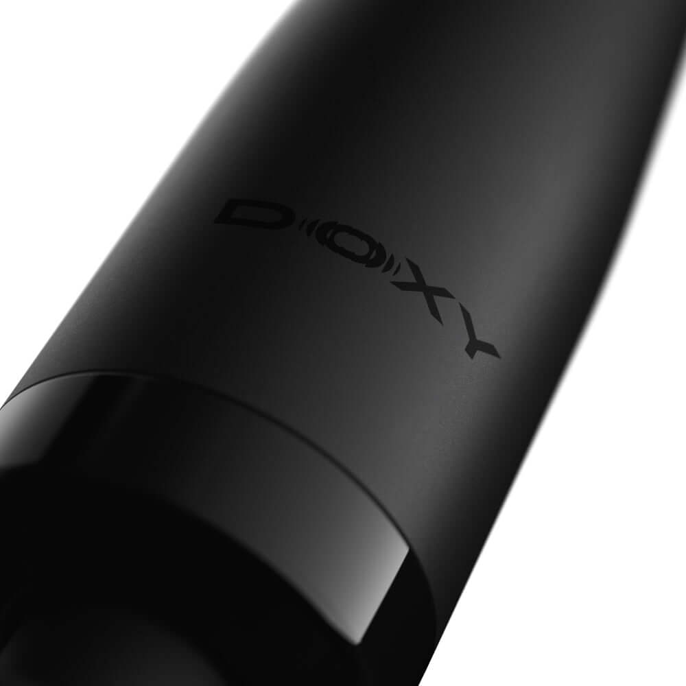 Close-up of the Doxy Die Cast Compact Cordless Wand Massager Black logo on a sleek black surface.