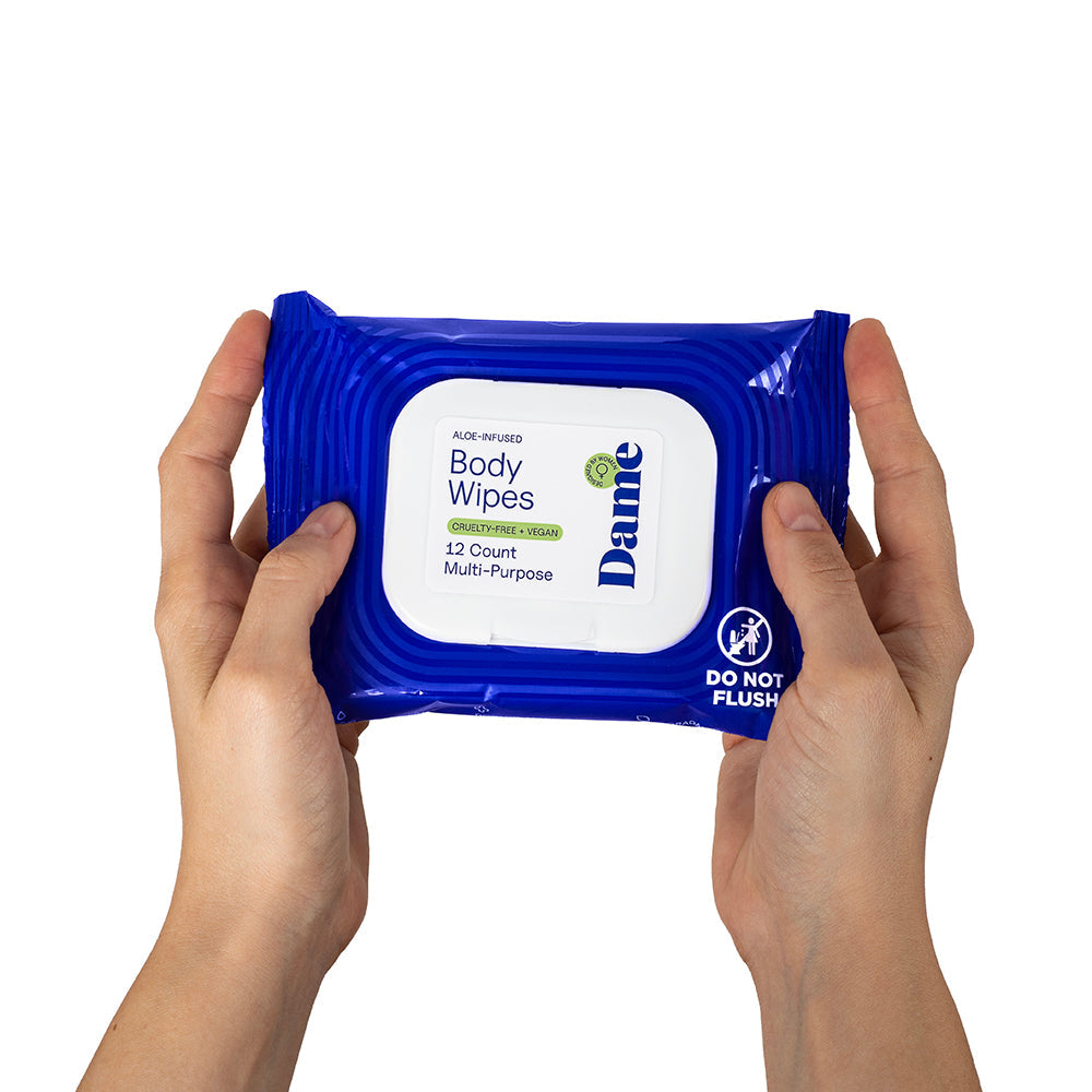 Dame Body Wipes 12 count Aloe & Cucumber cleansing wipes in hands, suitable for body refreshment and hydration.