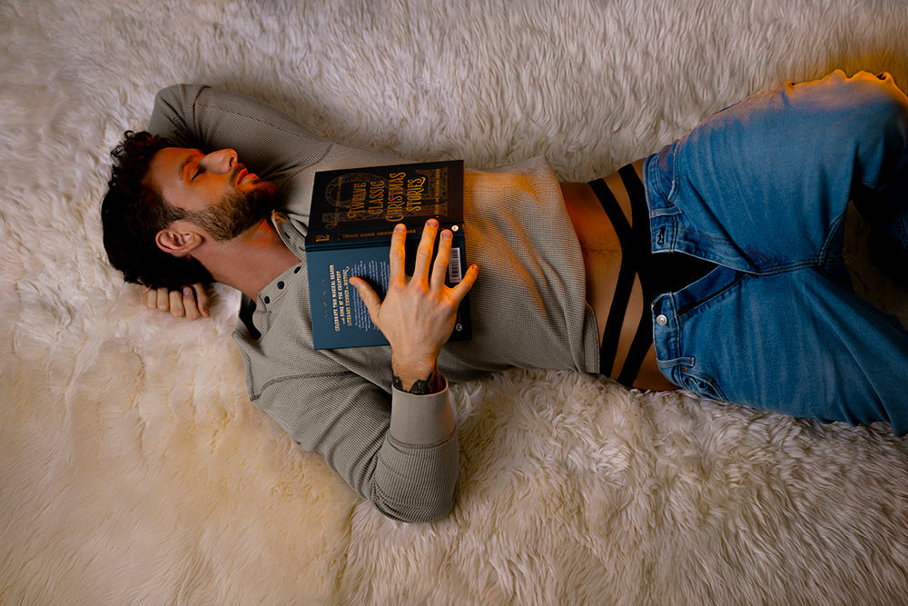 Male Power Eco Cozy Cutout Thong Green S/M modeled by a man reading a book while lying on a plush white rug.