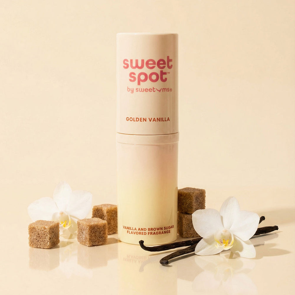 Sweetums Sweet Spot Flavored Fragrance Golden Vanilla with flowers and sugar cubes on a beige background.