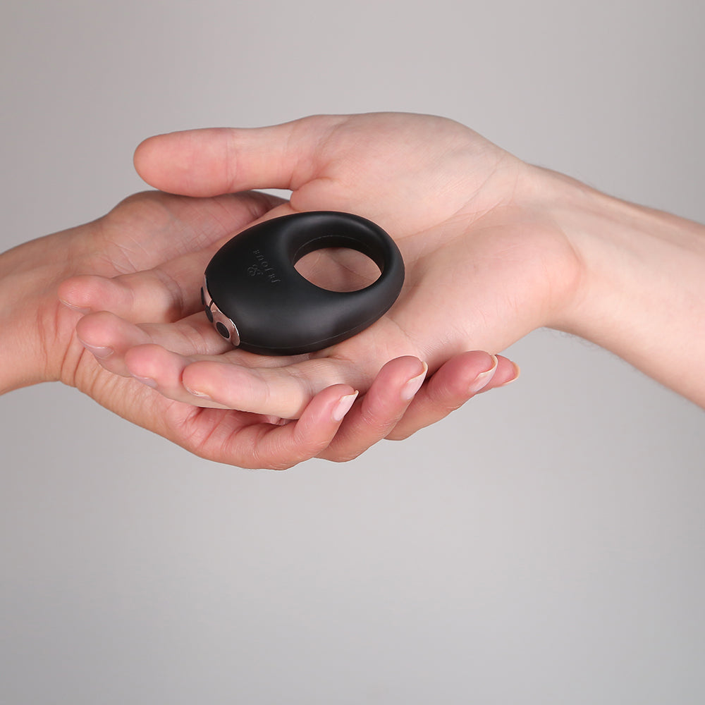 Je Joue Mio V2 Vibrating Cock Ring Black being held in a hand, showcasing its sleek design.