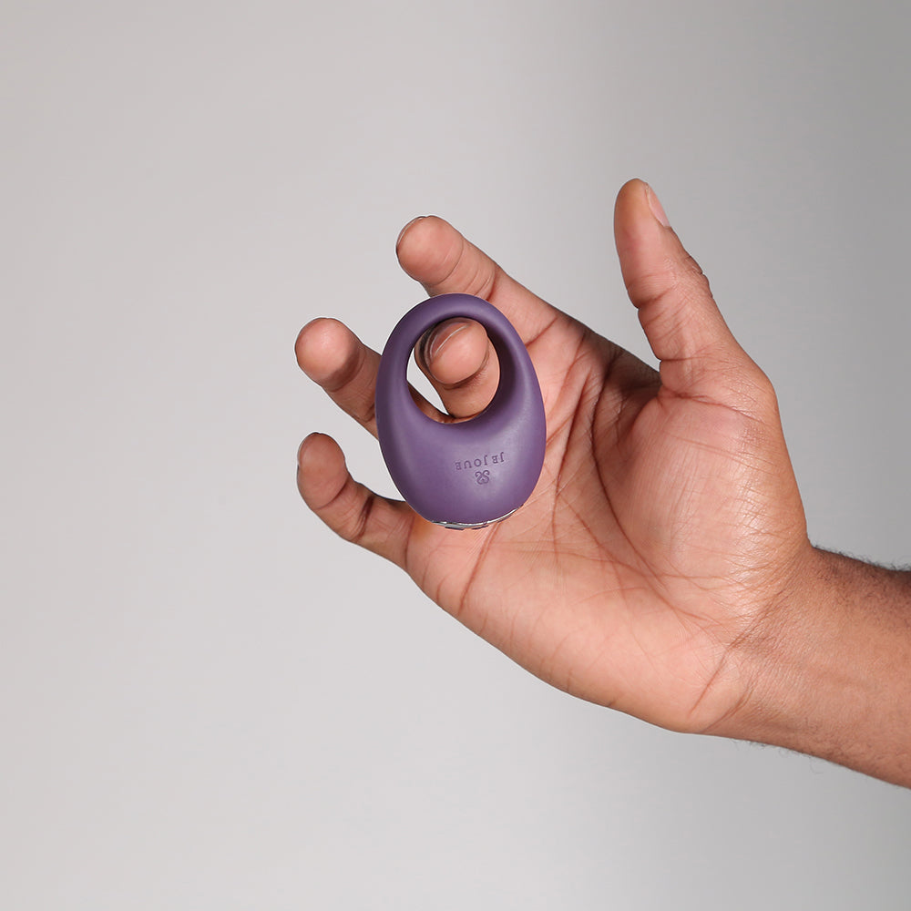Je Joue Mio V2 Vibrating Cock Ring Purple held in hand against a neutral background.
