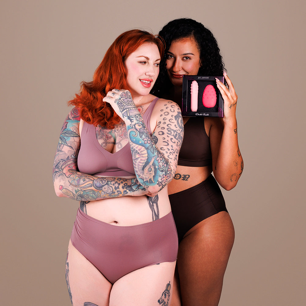 Two women showcasing the Je Joue Double Trouble Luxury Pleasure Toy in elegant packaging.