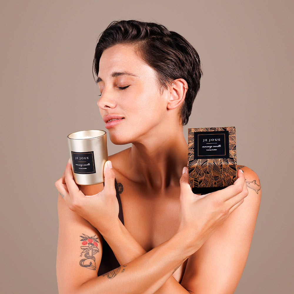 Woman holding Je Joue Luxury Leather Massage Candle 160g, promoting sensual relaxation and moisturizing skin.
