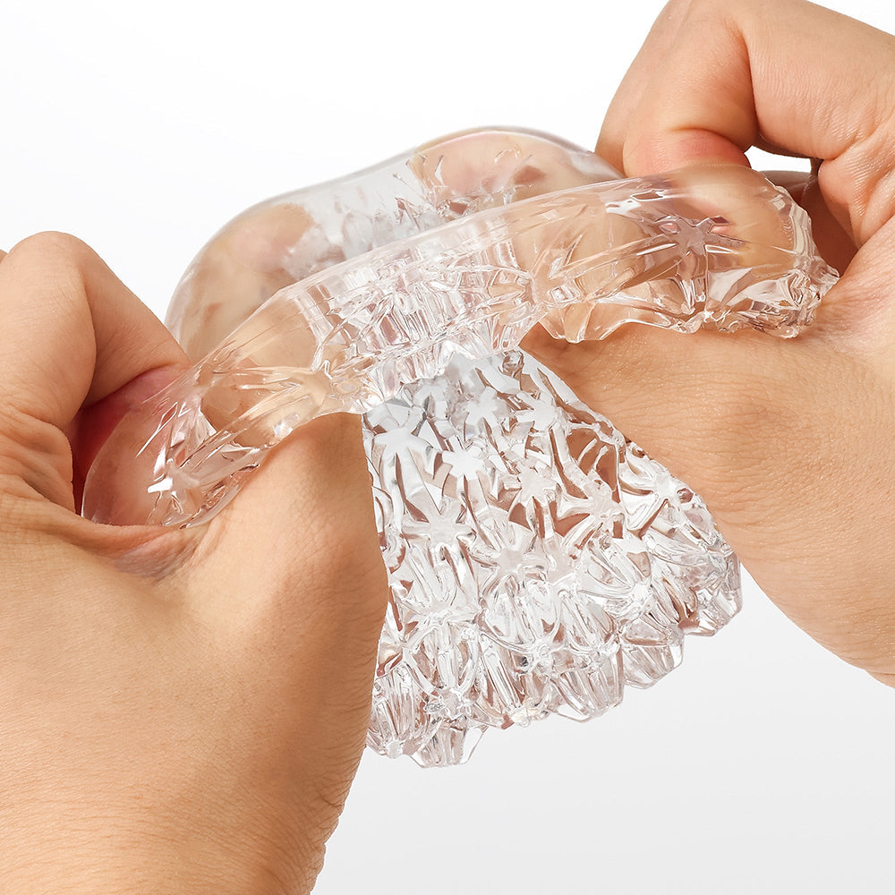 Hands demonstrating the Tenga Geo Aqua Masturbator Sleeve's unique textured design and flexible material.