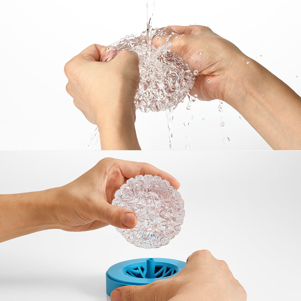 Hands holding the Tenga Geo Aqua Masturbator Sleeve under water, showcasing its texture and functionality.