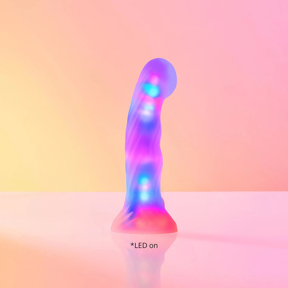 Love To Love Dildo Led Sugar Bomb with colorful LED lights on a soft surface.