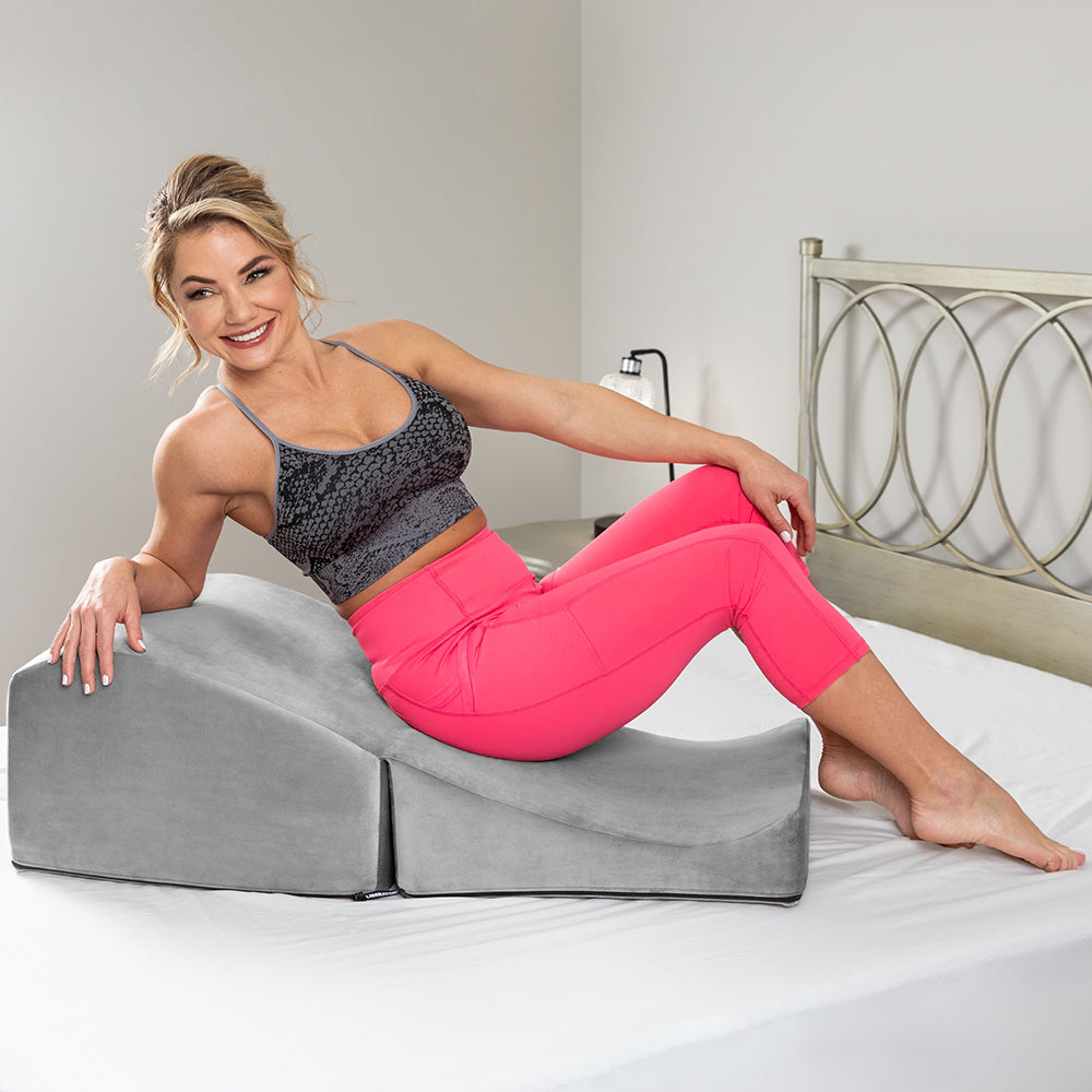 Woman using Liberator Flip Ramp Sex Positioning Pillow With Slip Cover Grey for comfort and support.