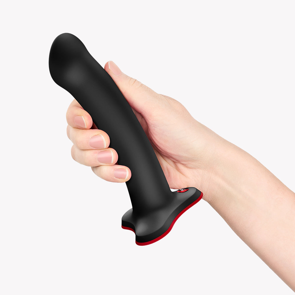 Person holding Fun Factory Magnum G-Spot Dildo Black with ergonomic design for pleasure.