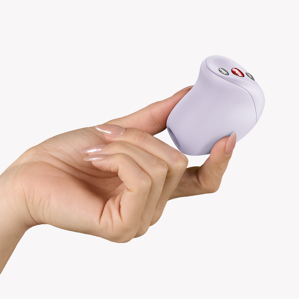 Hand holding the Fun Factory Mea Air Pulse Vibrator Purple showcasing its design and controls.
