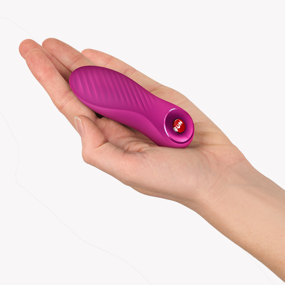 Fun Factory Bijou Bullet Vibrator Magenta held in a hand, showcasing its compact and travel-friendly design.
