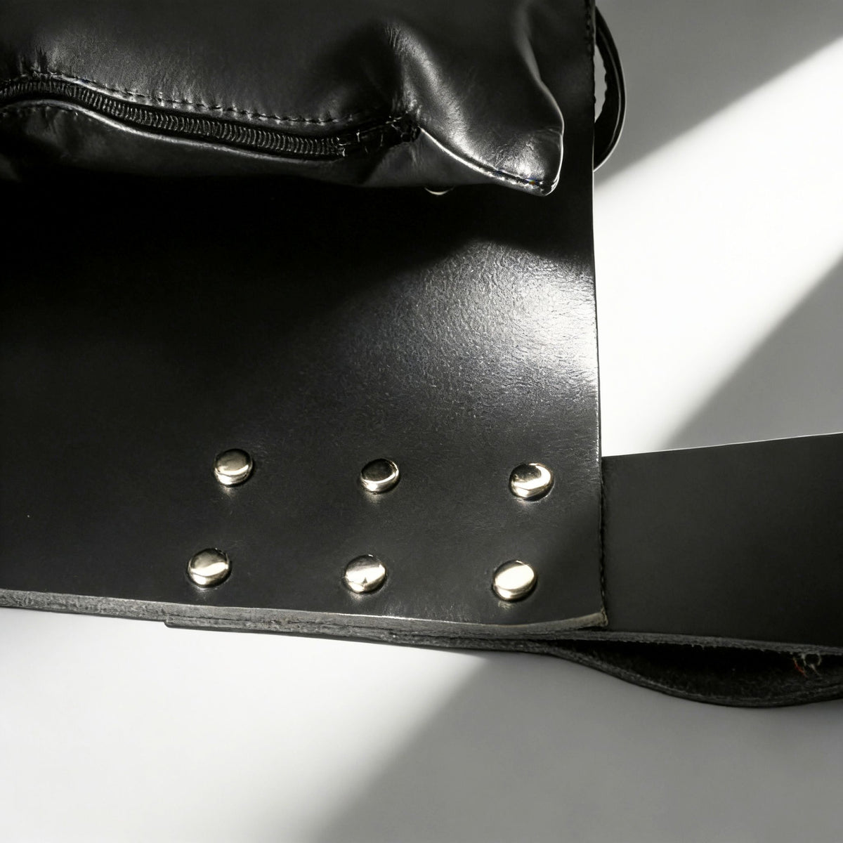Strict Leather Premium Black Leather Sex Sling with silver studs and zipper detail on black leather material.