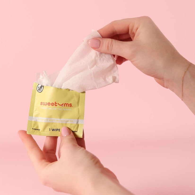 Sweetums Flavored Intimate Wipes Pina Colada being taken from packaging, perfect for refreshing intimate moments.