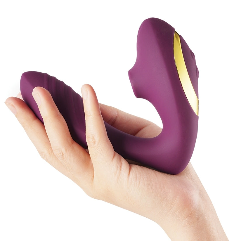 Tracy's Dog OG Clitoral Sucking Vibrator Purple held in hand showcasing its sleek design and silicone texture.