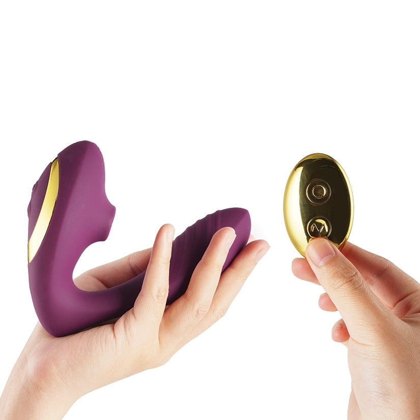 Tracy's Dog OG2 Clitoral Sucking Vibrator Purple with wireless remote in hand.