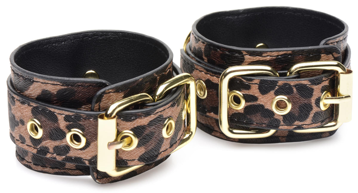 Master Series Wild Sex 7 Piece Jaguar Print Bondage Set - close-up of decorative cuffs in jaguar print with gold hardware.