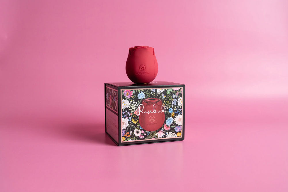 Alchemy Rosebud Luxury Air-Pulse Massager Red on floral themed box against a pink background.