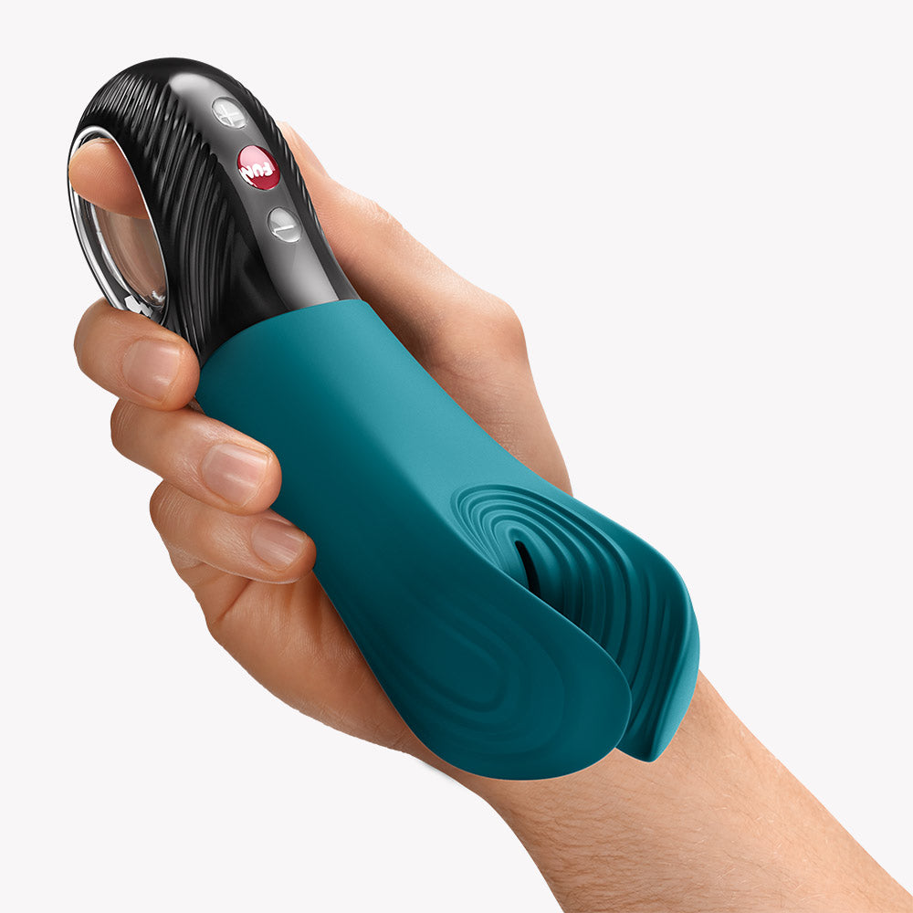 Fun Factory Manta Vibrating Masturbator Green held in a hand, showcasing its ergonomic design and flexible wings.